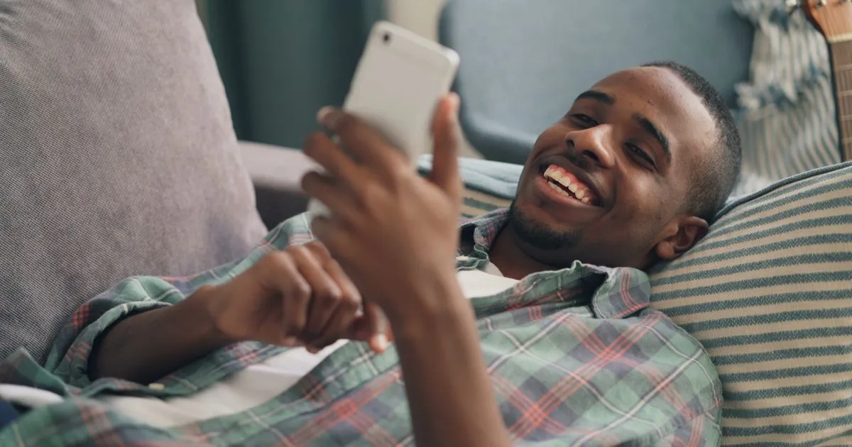 Happy man completing a quick loan application on his smartphone