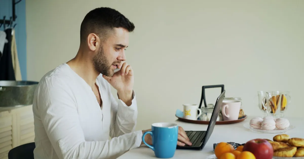 Quebec borrower confirming loan details by phone and laptop