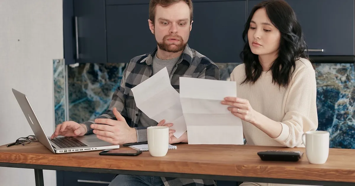 Couple at their kitchen table comparing quick loans Canada lenders offer with an overdraft and a pay advance