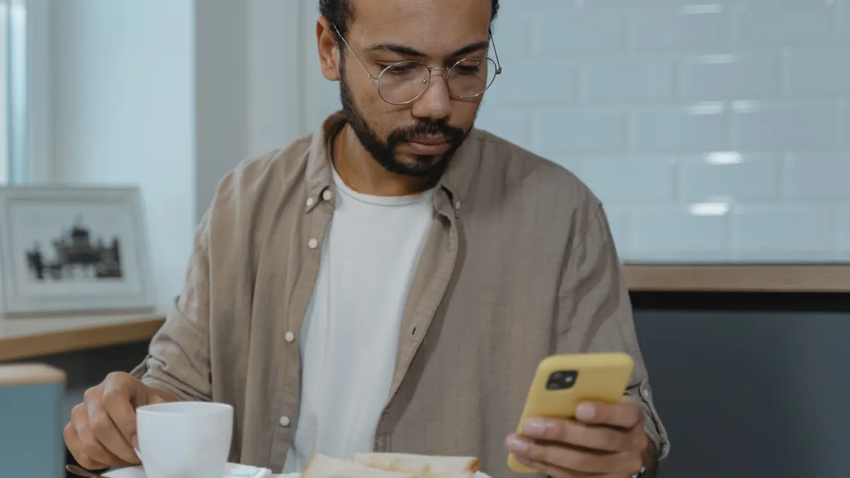 Man checking his pay deposits on his phone over breakfast before applying for bad credit quick loans